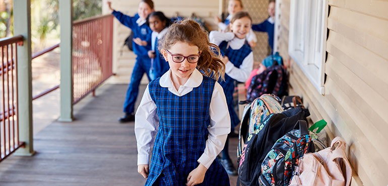SWS770-Young_female_student_in_glasses_smiling Students collect their bags outside the classroom.
